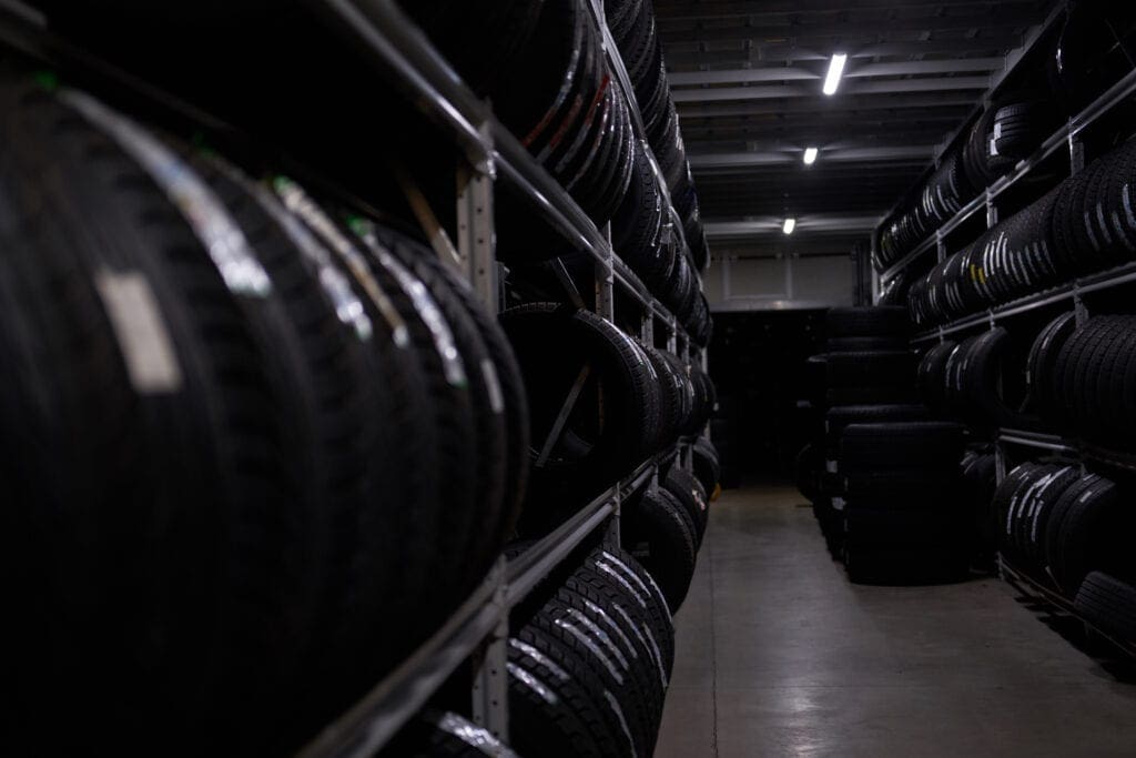 Dark storage full or big variety of new tires at busy storage warehouse.